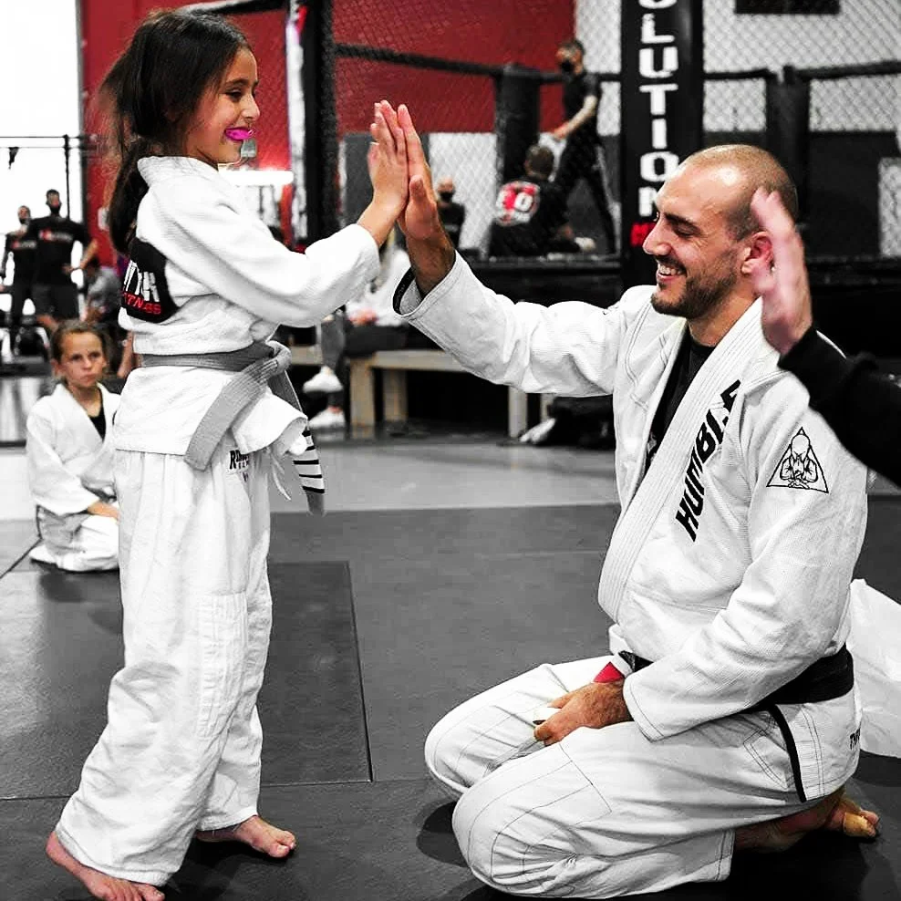 Brazilian Jiu Jitsu training at Evolution MMA with instructor and young student